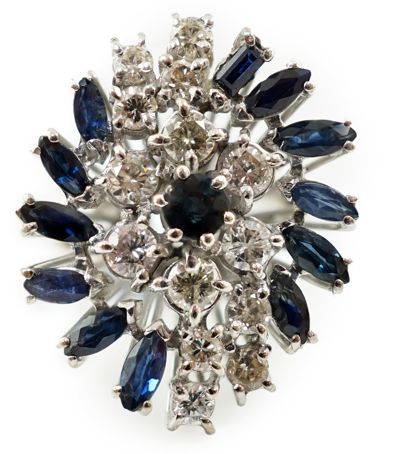 An 18k white gold, shaped cut sapphire and round cut diamond cluster set dress ring